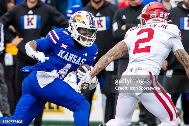 Kansas running back Devin Neal attempts to avoid the tackle of Oklahoma defensive back Billy Bowman Jr. During the game vs the Kansas Jayhawks and...