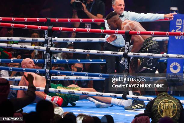 Britain's Tyson Fury falls on the ground as he fights against Cameroonian-French Francis Ngannou during their heavyweight boxing match in Riyadh...