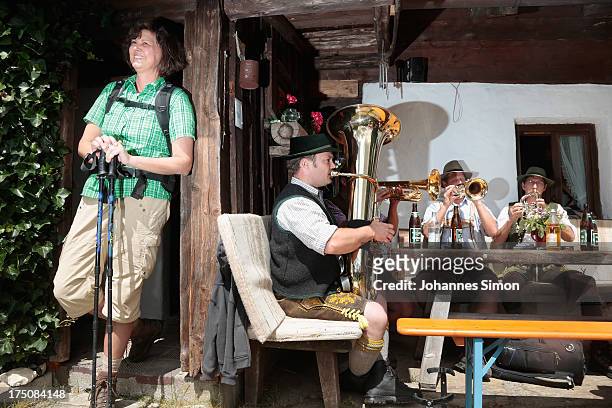 German Agriculture Minister Ilse Aigner listens to brass musicians as she arrives at an alpine alm during a hike in the Traunstein region of the...