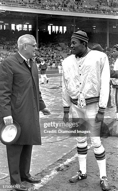 Wide receiver Paul Warfield of the Cleveland Browns talks with head coach Woody Hayes of the Ohio State Buckeyes during a game on circa 1966 at...