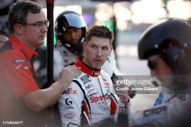 Denny Hamlin, driver of the Sport Clips Haircuts Toyota, and crew react to leaving the race after an on-track incident during the NASCAR Cup Series...
