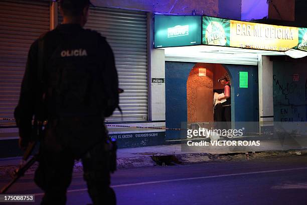Forensic personnel work at the crime scene where two men and two women were killed inside a bar called "Mi Oficina" by gunmen in the Nezahualcoyotl...