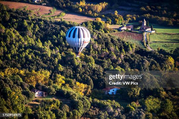 Hot air balloon flying La Fageda d' en Jorda and the volcanic area of Olot, the Natural Park of the Volcanic Zone of La Garrotxa and mountains on the...