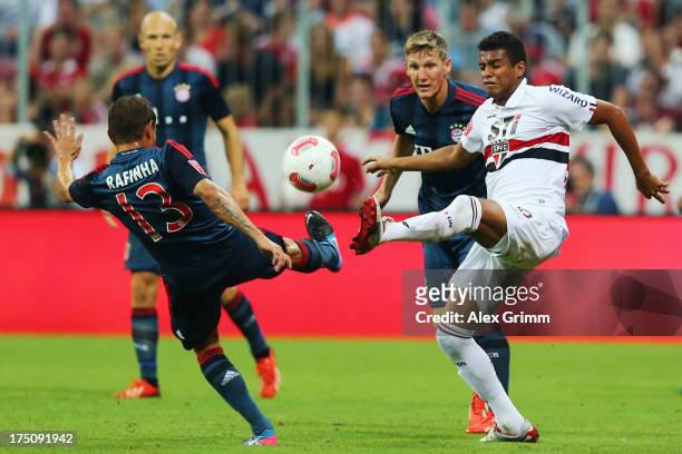 Rafinha of Muenchen is challenged by Reinaldo of Sao Paulo during the Audi Cup match between FC Bayern Muenchen and FC Sao Paulo at Allianz Arena on...