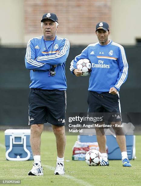 Head coach Carlo Ancelotti and assistant coach Zinedine Zidane of Real Madrid follow their players during a training session at UCLA Campus on July...