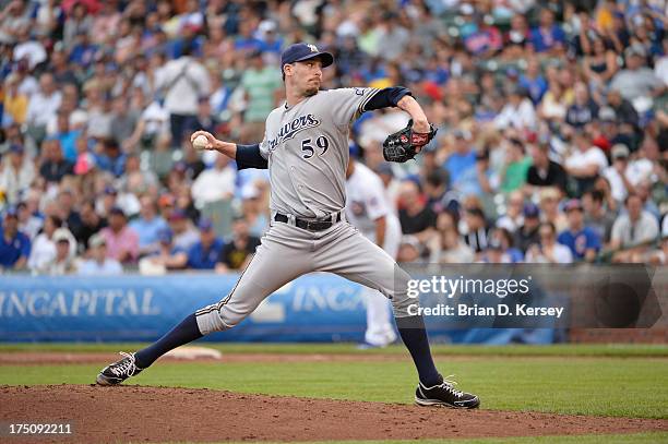 Relief pitcher John Axford of the Milwaukee Brewers delivers against the Chicago Cubs at Wrigley Field on July 30, 2013 in Chicago, Illinois. The...