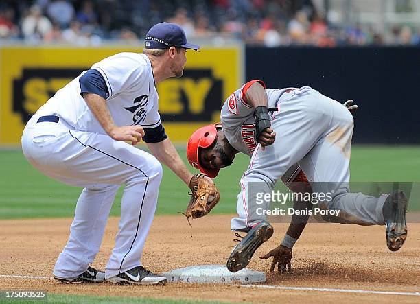 Brandon Phillips of the Cincinnati Reds is tagged out by Chase Headley of the San Diego Padres as he's caught stealing third base during the third...