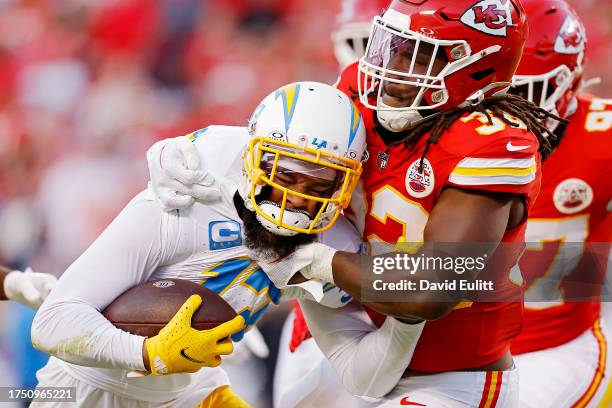 Keenan Allen of the Los Angeles Chargers is tackled by Nick Bolton of the Kansas City Chiefs during the fourth quarter at GEHA Field at Arrowhead...