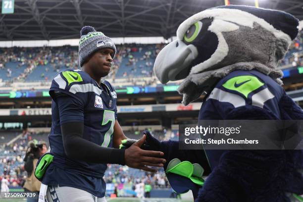 Geno Smith of the Seattle Seahawks shakes hands with Seattle Seahawks mascot Blitz the Seahawk after the game against the Arizona Cardinals at Lumen...