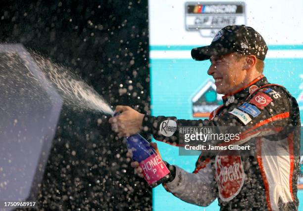 Christopher Bell, driver of the Rheem/Watts Toyota, celebrates by spraying champagne in victory lane after winning the NASCAR Cup Series 4EVER 400...