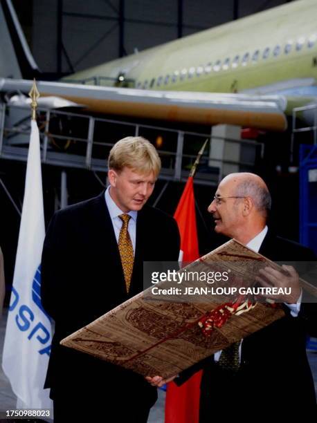 Dutch prince Willem Alexander is being offered a gift by Aerospatiale president Yves Michot, during their visit of the assembly line for Airbus A330...