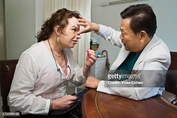 Dr. Preecha Tiewtranon inspects the face of Mandy, one his patients, after performing cosmetic surgery at the Bangkok Nursing Home hospital in...