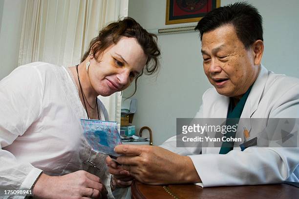 Dr. Preecha Tiewtranon inspects the face of Mandy, one his patients, after performing cosmetic surgery at the Bangkok Nursing Home hospital in...