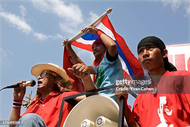 Red shirt protesters of the United Front for Democracy Against Dictatorship aboard a pick-up truck as they leave for a parade through Bangkok. The...