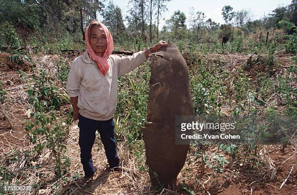 Phnong villager, Iglob, shows off a fragment of a bomb dropped from a B-52. The debris from ordnance dropped during the Vietnam war still litters the...