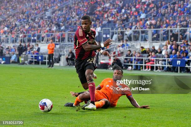 Xande Silva of Atlanta United avoids a tackle by Alvas Powell of FC Cincinnati during the first half of a MLS soccer match at TQL Stadium on October...