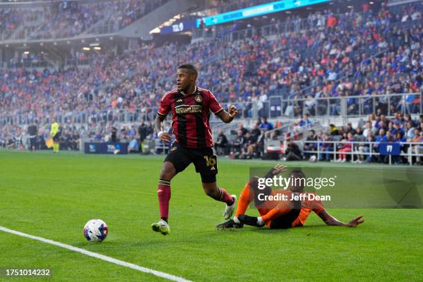 Xande Silva of Atlanta United avoids a tackle by Alvas Powell of FC Cincinnati during the first half of a MLS soccer match at TQL Stadium on October...