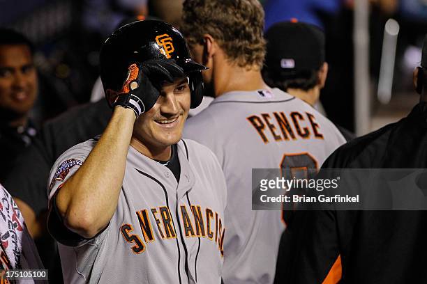 Brett Pill of the San Francisco Giants smiles in the dugout after hitting a solo home run in the seventh inning of the game against the Philadelphia...