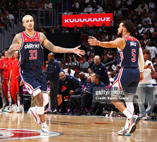 Kyle Kuzma and Tyus Jones of the Washington Wizards high five during the game against the Memphis Grizzlies on October 28, 2023 at Capital One Arena...