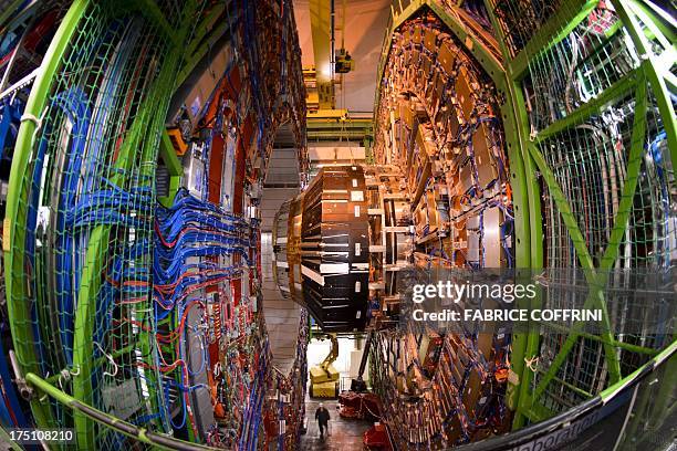 Worker stands below the Compact Muon Solenoid , a general-purpose detector at the European Organisation for Nuclear Research Large Hadron Collider ,...