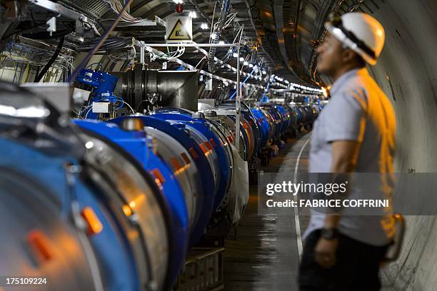 Scientist looks at a section of the European Organisation for Nuclear Research Large Hadron Collider , during maintenance works on July 19, 2013 in...