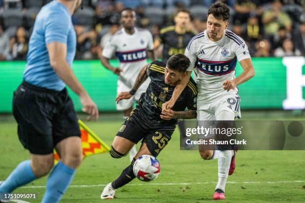 Cristian Olivera of Los Angeles FC battles Alessandro Schöpf of Vancouver Whitecaps during the MLS Round One Playoff match between Los Angeles FC and...