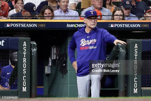 Manager Bruce Bochy of the Texas Rangers looks on from the dugout against the Houston Astros during the third inning in Game Six of the American...