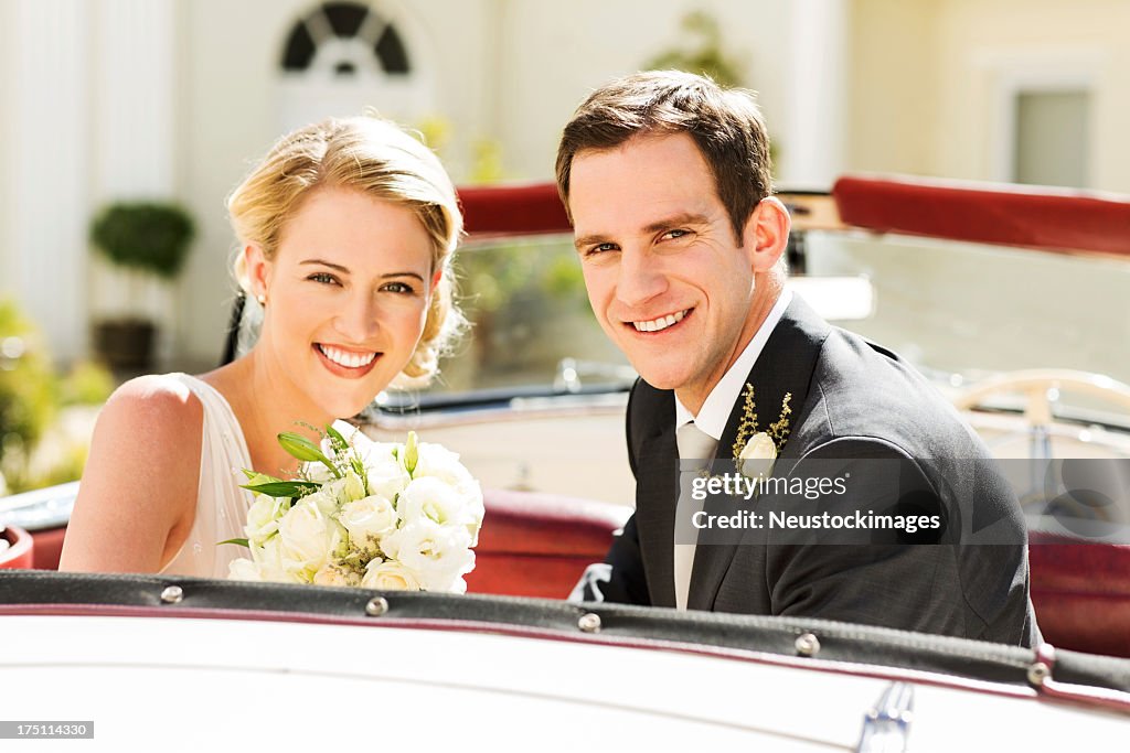 Newlywed Couple Smiling While Sitting In Car