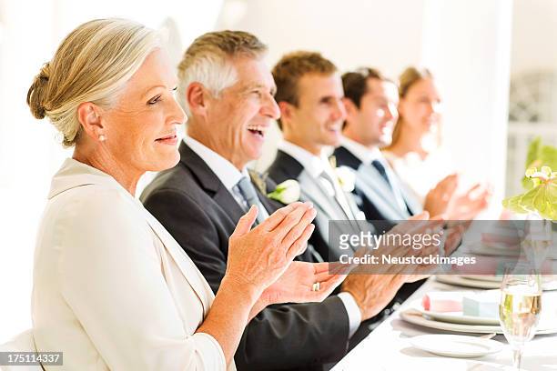 family and guests clapping at table during reception - parents applauding stock pictures, royalty-free photos & images