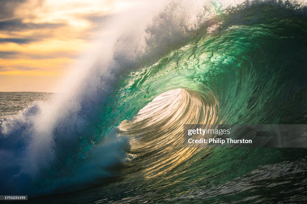 金色の光の中で浅いサンゴ礁を砕く海の波のエネルギー