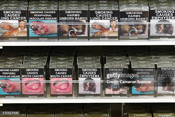Cigarette packets with health warnings are displayed in a convenience store on August 1, 2013 in Sydney, Australia. In a plan announced today, the...
