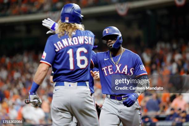 Adolis Garcia of the Texas Rangers celebrates with Travis Jankowski after hitting a grand slam home run against Ryne Stanek of the Houston Astros...