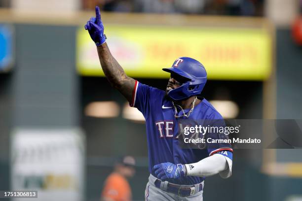 Adolis Garcia of the Texas Rangers celebrates as he rounds the bases after hitting a grand slam home run against Ryne Stanek of the Houston Astros...