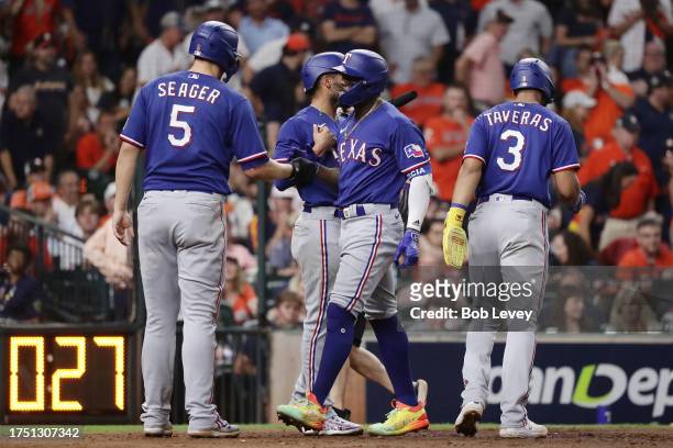 Adolis Garcia of the Texas Rangers celebrates with Corey Seager after hitting a grand slam home run against Ryne Stanek of the Houston Astros during...