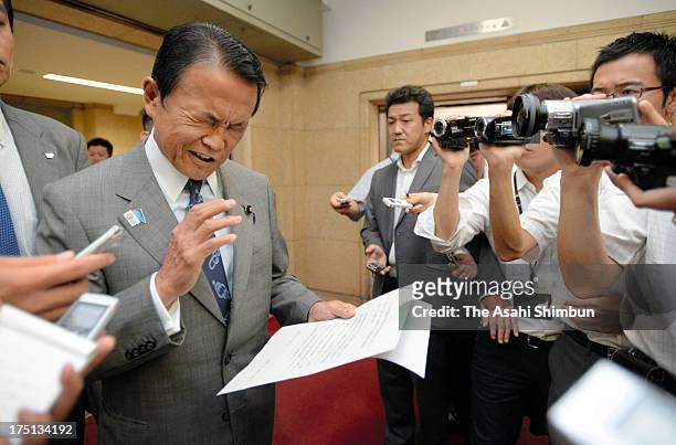 Japanese Deputy Prime Minister and Finance Minister Taro Aso reads a comment to retract his recent remarks at Finance Ministry on August 1, 2013 in...