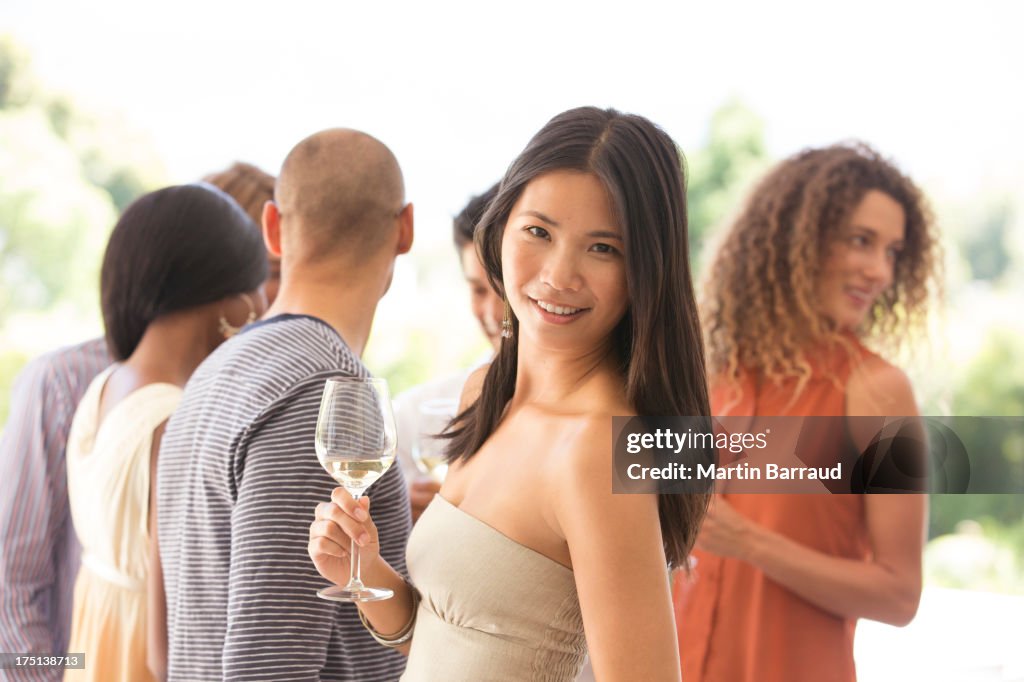 Woman having glass of wine at party