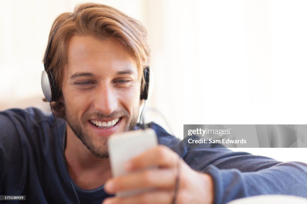 Homem ouvir para auscultadores no sofá