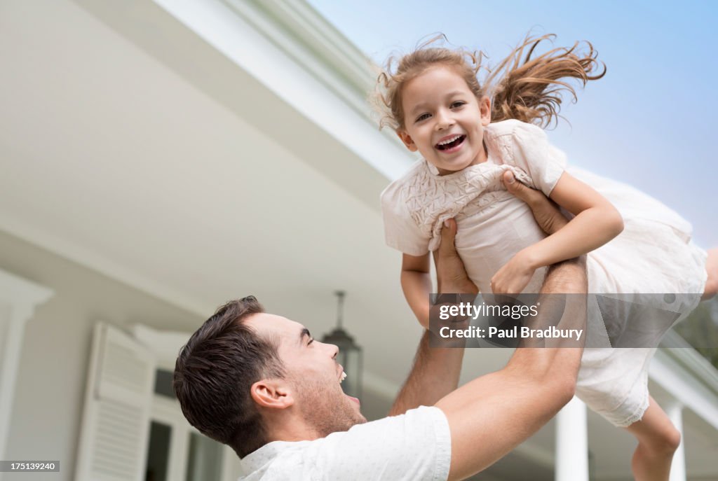 Father and daughter playing outside house