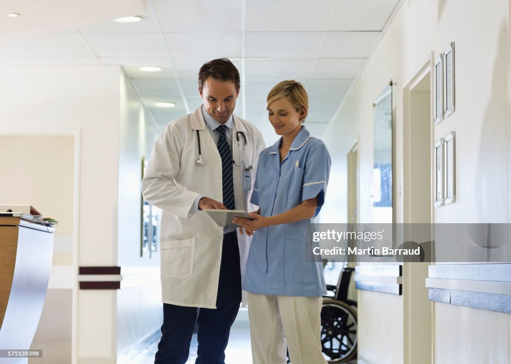 Médico y enfermera con tableta en el hospital Corredor