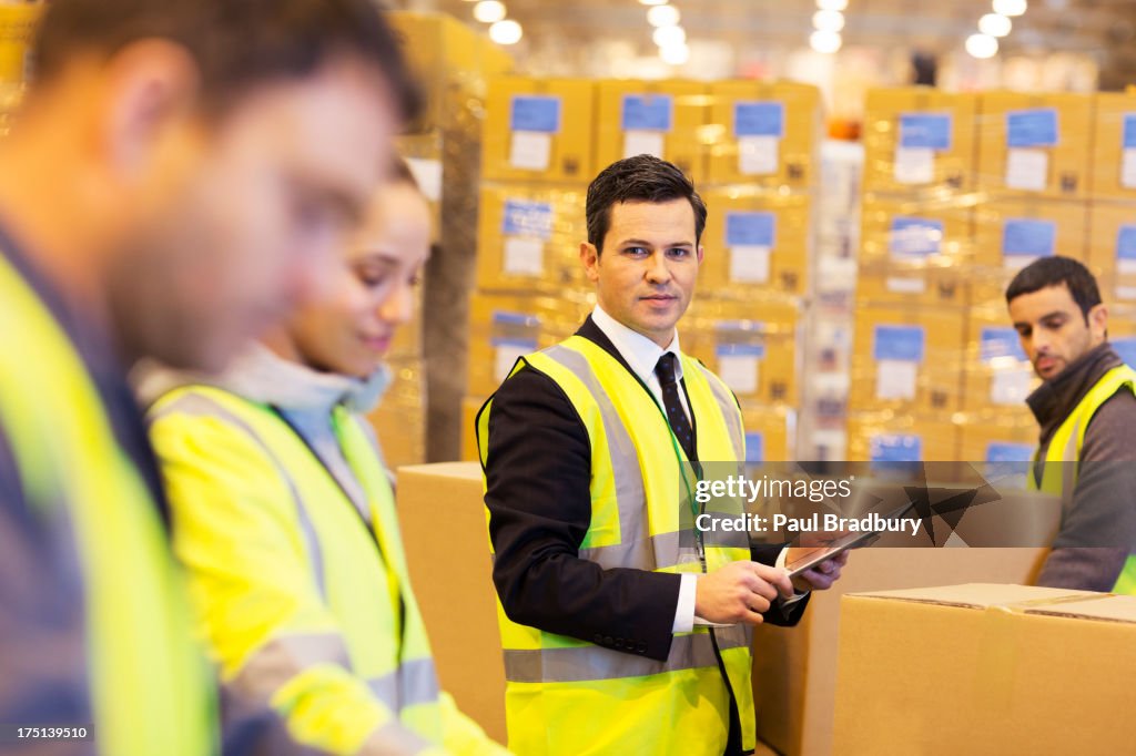 Businessman and workers in warehouse