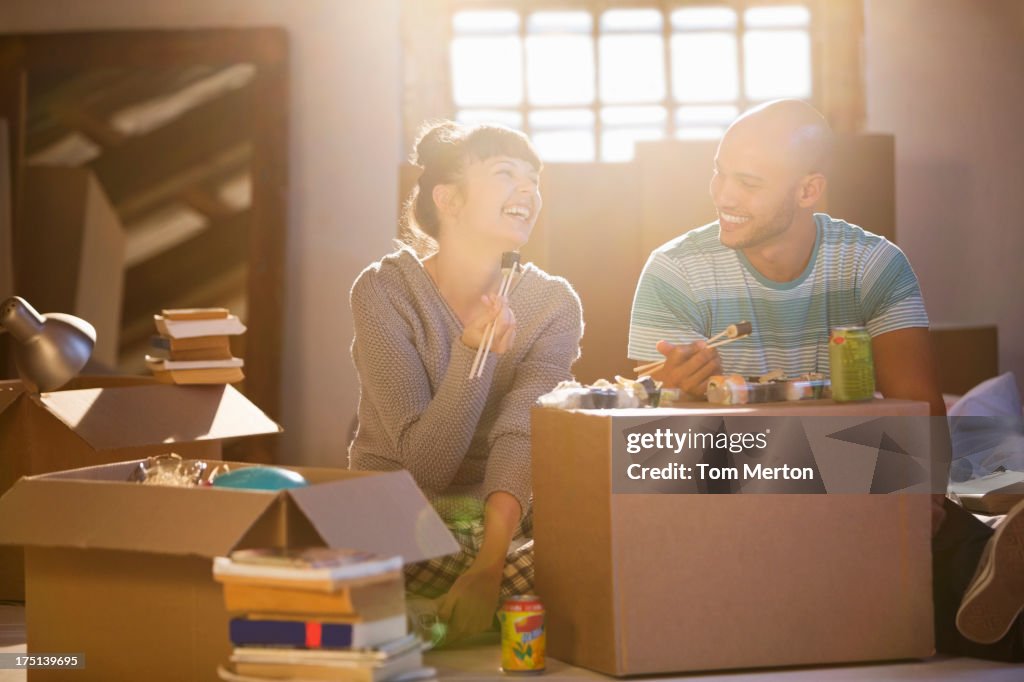 Couple eating sushi together in new home