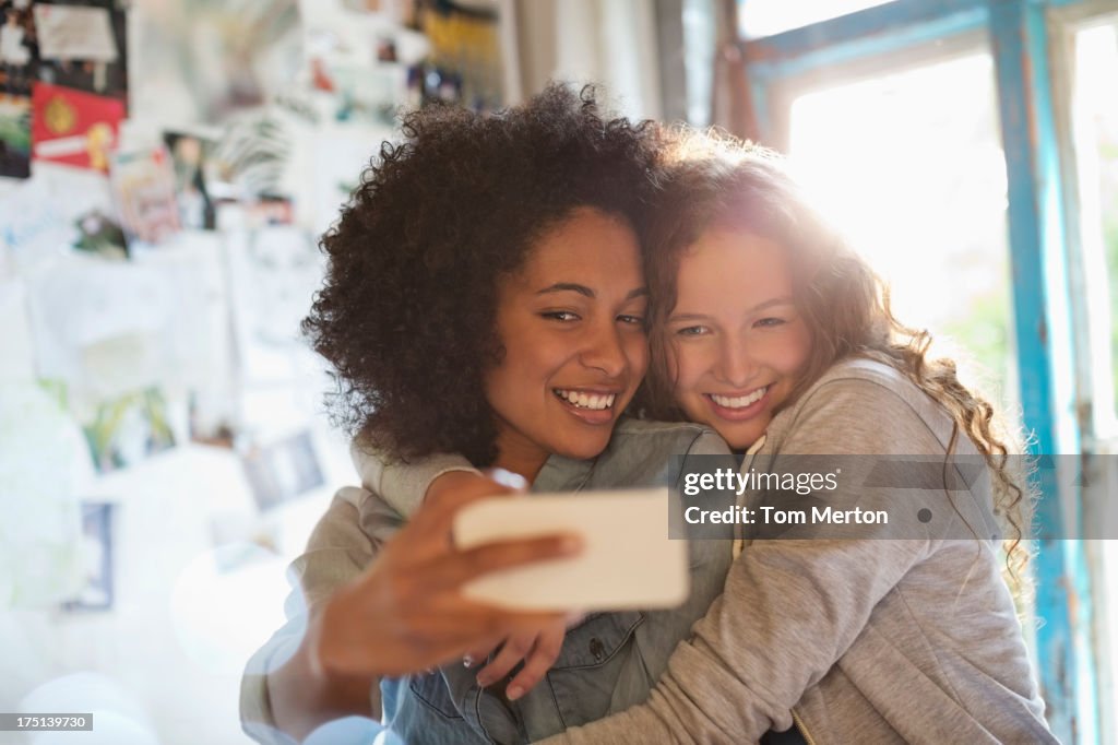 Women taking picture together in bedroom