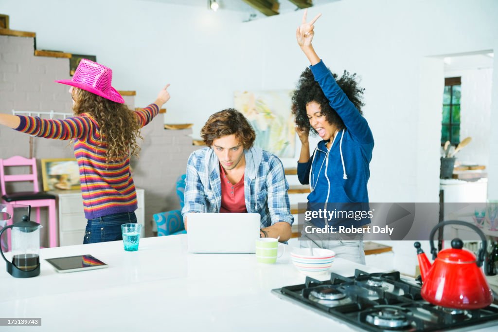 Mujeres bailando en el hombre en la cocina