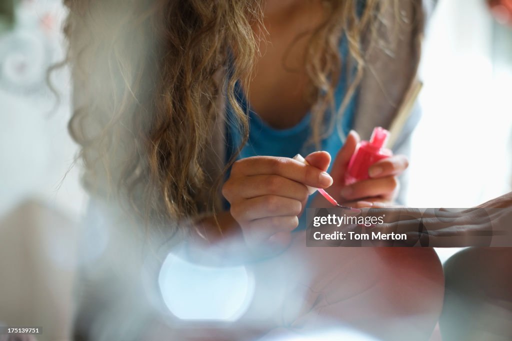 Woman painting friend's nails