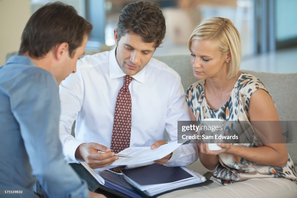 Financial advisor talking to couple on sofa