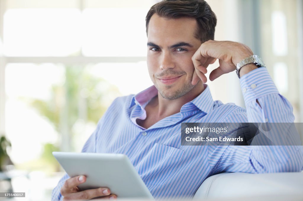 Businessman using tablet computer on sofa