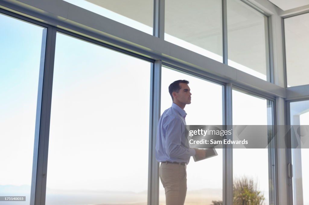 Businessman using tablet computer at window