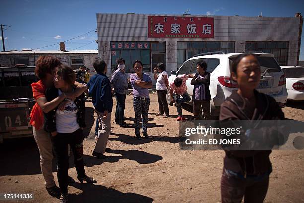 Photo taken on August 20, 2012 shows people standing next to a roadside restaurant near a state-owned rare earth mine north of the inner Mongolian...