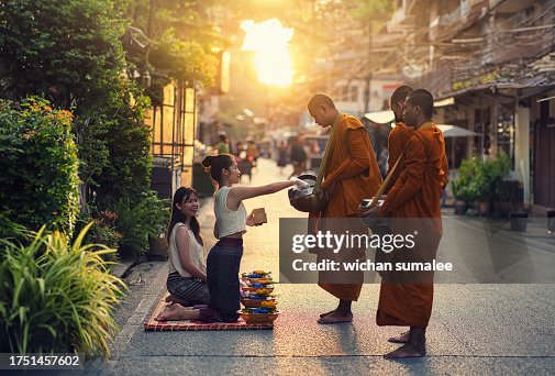 Woman giving alms to monks