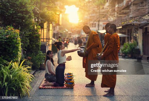 woman giving alms to monks - alms stock pictures, royalty-free photos & images